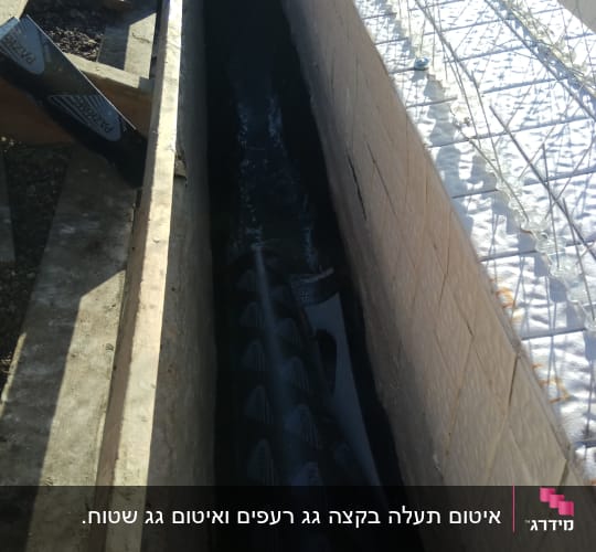 חומר איטום שחור מונח בתעלה בין קירות